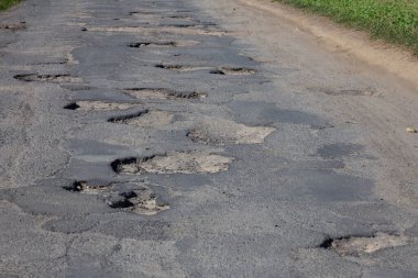 Asfalttaki deliklerle dolu yol. Tümsek. 
