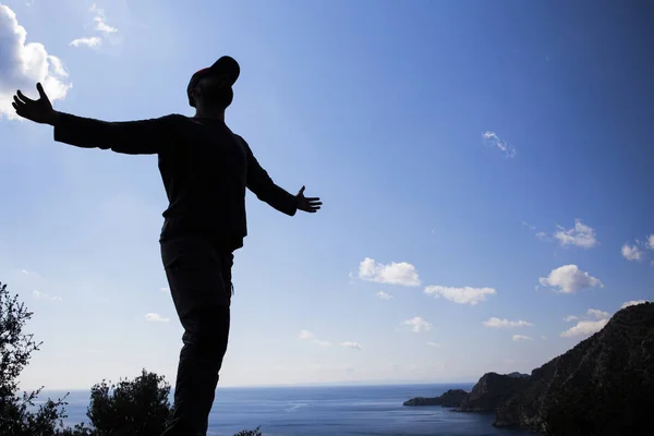 Silhueta de homem feliz e sozinho na montanha com sol e céu . — Fotografia de Stock