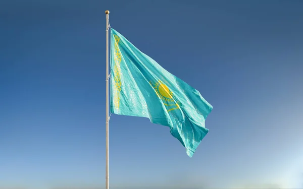 Kazakistan ulusal bayrağı, günbatımında gökyüzü arka planında rüzgarda dalgalanıyor. Güzel vatansever duvar kağıdı