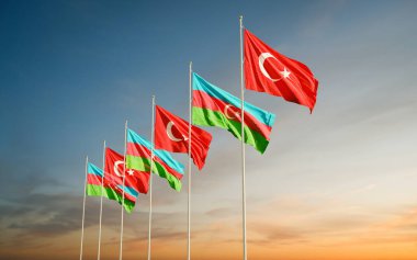 Azerbaycan ve Türkiye 'nin bayrakları gün doğumunda gökyüzünde dalgalanıyor. Karabağ 'da Ermenistan' la yaşanan savaş sırasında uluslararası anlaşmanın ve desteğin sembolü.