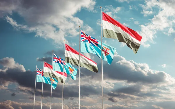 Hungary and Fiji flags waving at sunset sky background. Concept of international Hungarian Fijian relations.