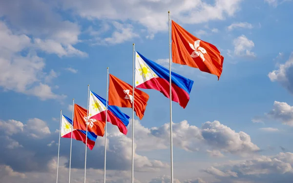 The Philippine and Hong Kong flags fly together in the wind against the blue sky. The concept of cooperation and competition in economics and politics. Flag of the Philippines to the left of Hong Kong.