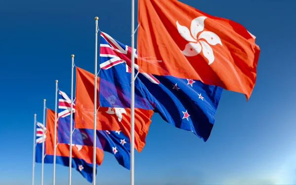 The New Zealand and Hong Kong flags fly together in the wind against the blue background. The concept of cooperation and competition in economics and politics. Flag of the New Zealand to the left of Hong Kong.