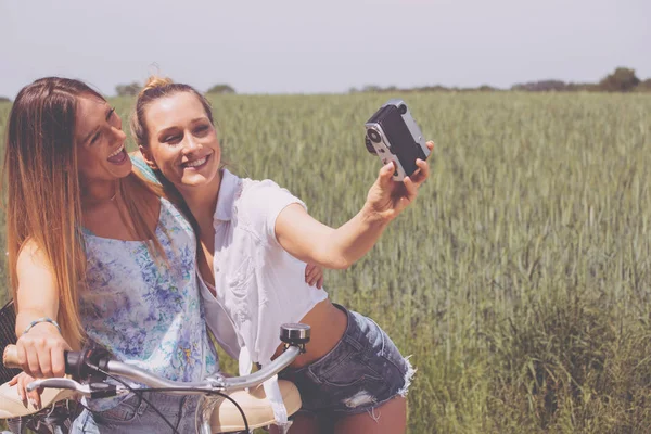 Hermanas gemelas haciendo una selfie con cámara retro — Foto de Stock