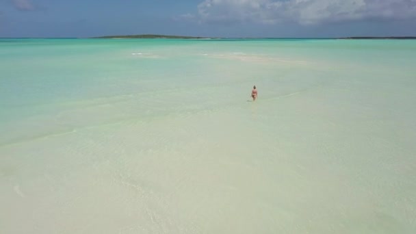 Donna che cammina su un banco di sabbia alle Bahamas . — Video Stock