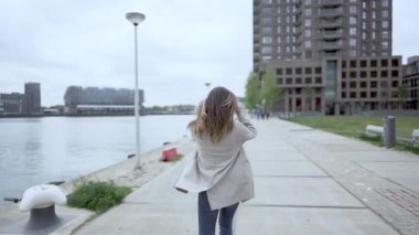 mutlu genç kadın yürüyüş ve etrafında spin. Slowmotion