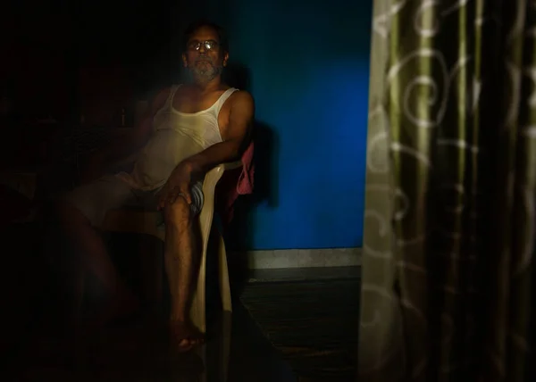 Delhi, Hindistan - 12 Haziran 2020: Sandalyede oturan bir adam akşam çayını bekliyor.