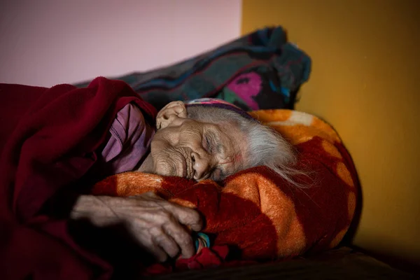 Uttrakhand, Hindistan - 05 Kasım 2019: Yatağında dinlenen güzel yaşlı bir kadın