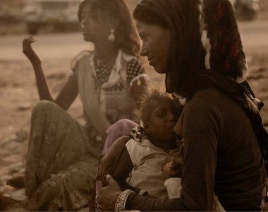 Puşkar, Rajasthan / Hindistan - Kasım 2019: Bir kadın çocuğunu her yıl Pushkar kentinde düzenlenen çoklu hayvan fuarı ve kültür şöleniyle besliyor.