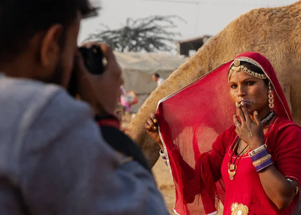Puşkar, Rajasthan / Hindistan - Kasım 2019: Pushkar kentinde düzenlenen yıllık çoklu hayvan fuarı ve kültür festivalinde kameraya poz veren bir kadın.