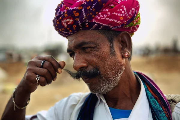 Puşkar, Rajasthan / Hindistan - Kasım 2019: Yıllık çiftlik hayvanları fuarında bıyıklarını sallayan bir adam, Pushkar Fuarı.