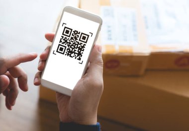 Ufaklıkla çevrimiçi alışveriş kavramları, ürün kutusu üzerinde qR kodlu akıllı telefon kullanıyor. E ticaret pazarı. Ulaşım lojistiği. İş perakendecisi.