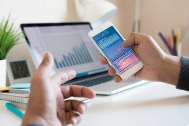 Akıllı telefon ve dizüstü bilgisayarda veri grafiği izleyen gençlerle ilgili büyük veriler veya dijital pazarlama veya kavramlar. İş araştırmaları