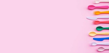 Renkli tablo üzerinde renkli kaşık ve çatal ögesinin üst görünümü. Düz dizayn