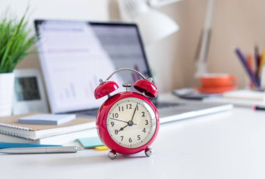 Masanın üzerinde kırmızı saat olan iş kavramları. Yatırım analizi için, fikir üretmek için. Zaman ve çalışma günü.