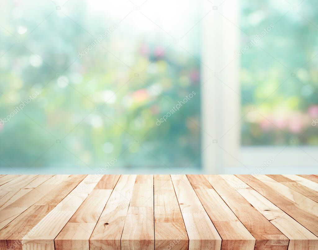 Wood table top on blur of window with garden flower background in morning.For montage product display or design key visual layout