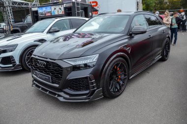 Yüksek performanslı lüks matte siyah SUV Audi RS Q8, agresif ön ve arka tamponları, çamurlukları ve öne çıkan bir ayırıcısı olan geniş gövdeli bir kite sahiptir.