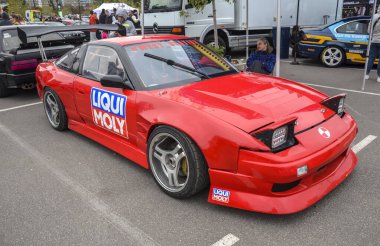 Kırmızı Nissan 240SX coupe S13, JDM simgesi, hafif şasisi ile tanınır, arkadan itiş gücü ve mükemmel dengesi ile ünlüdür, bu da onu sürüklenirken favori kılar.