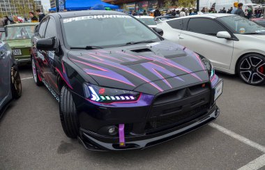 Özel yapım siyah Mitsubishi Lancer Evolution X, yüksek performanslı spor sedan çarpıcı mor ve pembe grafik ambalajlar, geniş gövdeli çamurluklar ve sonraki pazar tekerlekleri