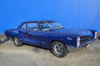 Klasik mavi 1966 Pontiac Catalina üçüncü nesil geniş iç mekan ve güçlü V8 motorlarıyla bilinen tam boyutlu bir arabadır.