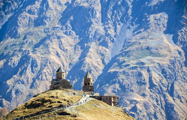Ortaçağ Ortodoks Gergeti Trinity Kilisesi engebeli bir tepenin üzerinde duruyor, arkasında Büyük Kafkas dağları var. Georgia