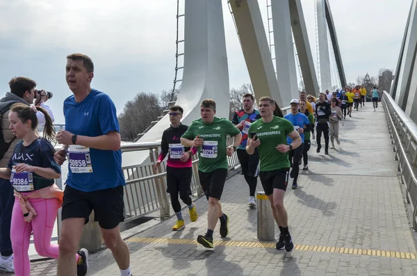 Şehir köprüsünde organize bir maratonda koşan sporcular, adanmışlık, zindelik ve rekabet sergiliyorlar.