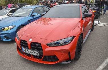 Kırmızı beşinci nesil BMW M4 (G82), bu neslin belirgin bir özelliği olan dikey böbrek ızgarası da dahil olmak üzere agresif stiliyle tanınır.