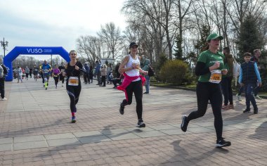 Koşucular manzaralı bir park alanı üzerinden yarışma maratonuna katılıyorlar. Çeşitli katılımcılar ellerinden gelenin en iyisini yaparak spor ve toplum ruhunu kucaklıyorlar.