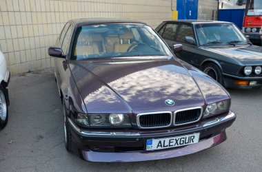 Koyu mor BMW E38, 7 serisi lüks sedanın üçüncü nesli. Şık ve zamansız tasarımıyla tanınıyor. Genellikle BMW 'nin tasarımı için yüksek bir nokta olarak kabul edilir.