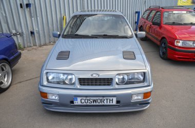 Açık mavi Ford Sierra RS Cosworth, parlak tekerlek kemerleri ve derin bir ön spoiler da dahil olmak üzere agresif stiliyle 1980 'lerin performans arabalarının gerçek bir simgesi haline geldi.