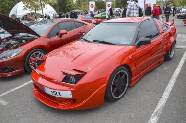 Kırmızı birinci nesil Mitsubishi Eclipse (1G) parlak, aerodinamik far tasarımı ve doğayı sürmek için eğlenceli olan spor kompakt arabası