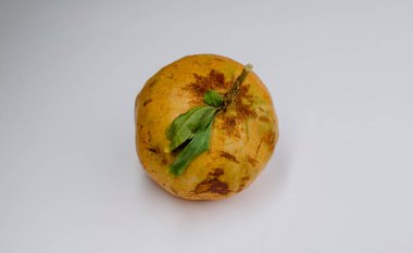 Saplı nar meyvesi ve beyaz arka planda yapraklar ve benekli, 4k kalite.