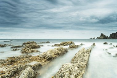 Dalgaların yumuşaklığı bir kaya plajındaki kaya elektrik hatlarından geliyor.