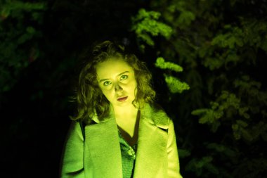 Yeşil ışıkta gizemli güzel bir kadının portresi.