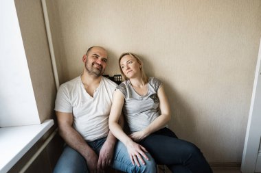 Evli bir çift karı koca mutfağın köşesinde oturuyorlar.