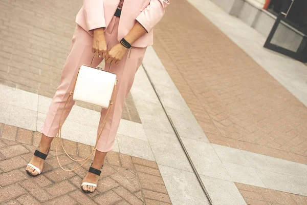 A woman in fashionable pantsuit pale pink dusty color