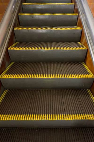 Velha escada rolante suja com riscas de advertência amarelas no metrô — Fotografia de Stock