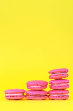 Sarı arka planda pembe macaroons. Sınıflandırma ve büyüme kavramları