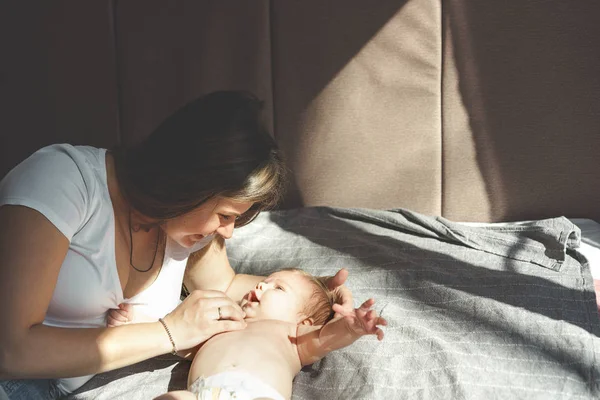 Bebé de dos meses sin ropa, desnudo, acostado en un pañal y sonriendo a la madre —  Fotos de Stock