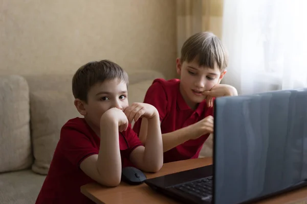 Dos hermanos están sentados en la sala de estar y jugando con la PC —  Fotos de Stock