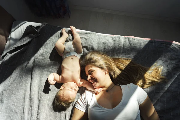 Mère avec son fils nouveau-né couché sur le lit — Photo