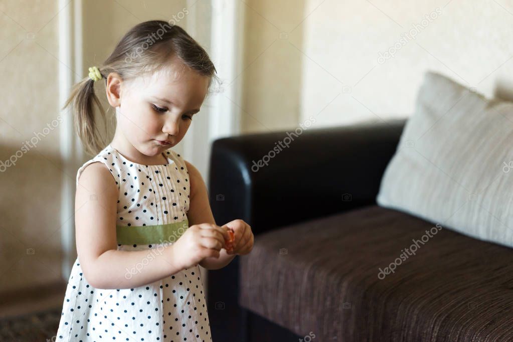 Girl unwrapping candy at home. Sweet home