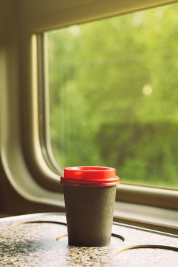 Kırmızı plastik kapaklı kağıt kahve fincanı.