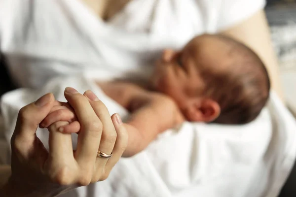 Pequeña mano de un recién nacido en una gran mano de madre —  Fotos de Stock