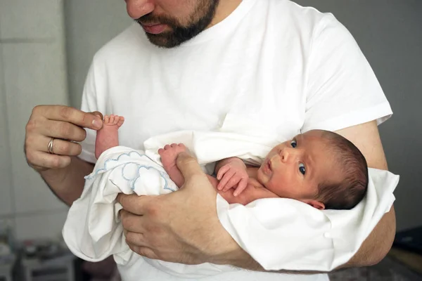 Padre sostiene al recién nacido desnudo en sus manos con un pañal blanco —  Fotos de Stock