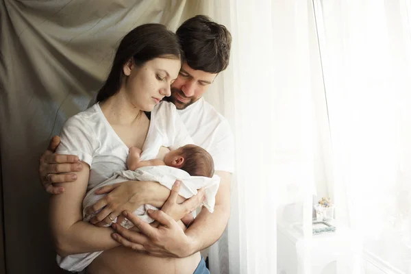 Padre y madre con un hijo recién nacido. Nueva familia joven multigeneración —  Fotos de Stock