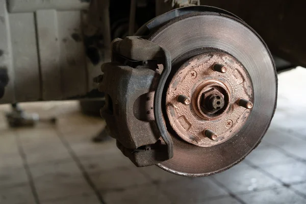 Old worn brake discs on a passenger car. Car on a lift in a car service — Stock Photo, Image