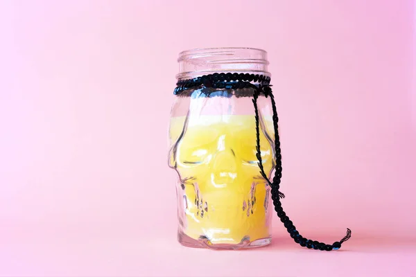 创意万圣节作曲 假日庆祝黄色蜡烛骷髅杯 粉色彩色纸背景 设计社交媒体的模板贺卡 为浪漫派对喝冷饮 — 图库照片