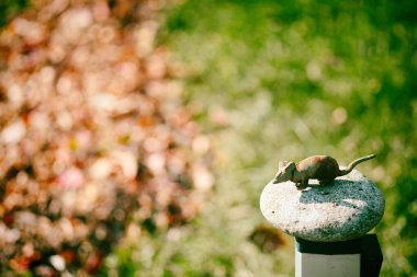 Sonbahar manzarasında küçük bir oyuncak fare. Kır evi dekorasyonu