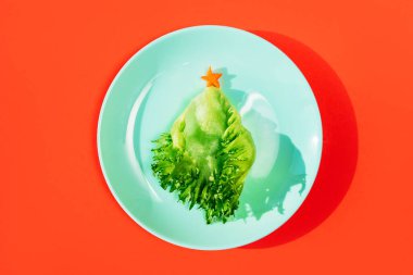 Bebek mısır, marul yaprağı ve havuçtan yenebilir komik bir Noel ağacı..